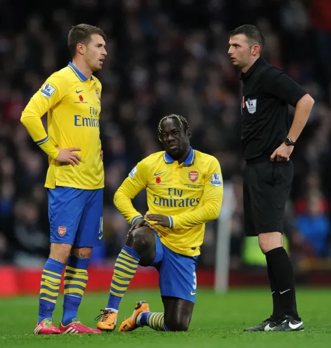 Framed Print : Arsenal's Sagna and Ramsey Confer with Referee Oliver during Manchester United Clash (2013-14) Framed Print : Arsenal's Sagna and Ramsey Confer with Referee Oliver during Manchester United Clash (2013-14)
