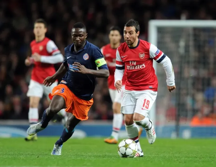Framed Print : Arsenal's Santi Cazorla Clashes with Montpellier's Mapou Yanga-Mbiwa in UEFA Champions League Showdown