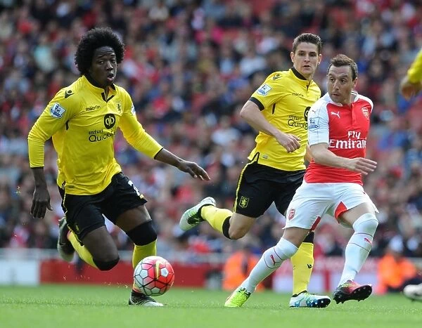 Arsenal's Santi Cazorla Faces Intense Pressure from Aston Villa's Midfield Duo