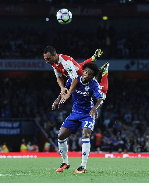 Arsenal's Santi Cazorla Soars Above Chelsea's Willian: Intense Moment from the Arsenal v Chelsea Clash (2016-17)