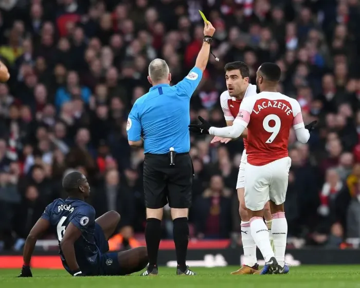 Framed Print : Arsenal's Sokratis Fouls Manchester United's Pogba: Jon Moss Issues Yellow Card (Arsenal v Manchester United 2018-19)