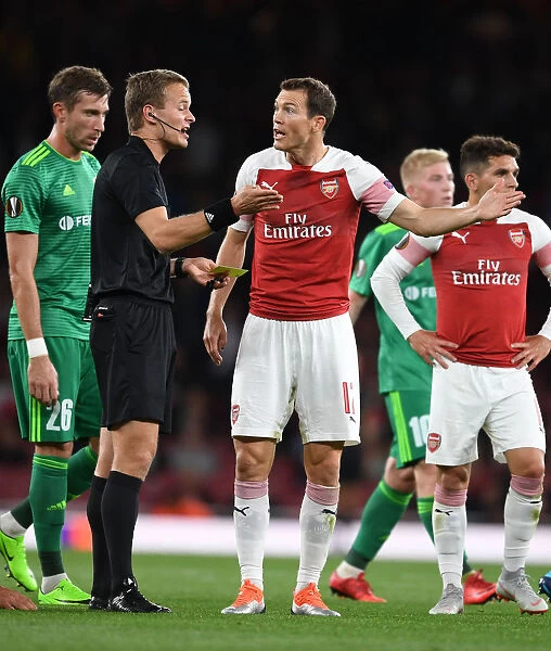 Arsenal's Stephan Lichtsteiner Faces Off with Referee Bart Vanyzere in Heated Europa League Clash