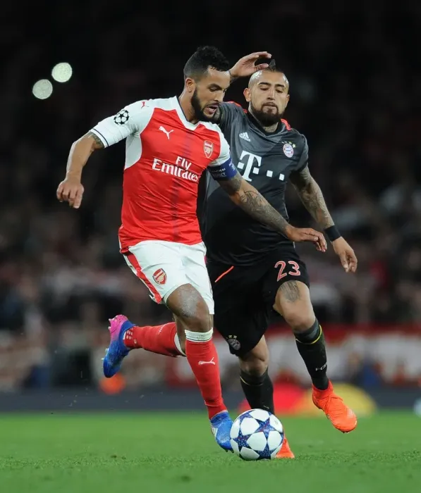 Framed Print : Arsenal's Theo Walcott Clashes with Bayern Munich's Arturo Vidal in UEFA Champions League Showdown Framed Print : Arsenal's Theo Walcott Clashes with Bayern Munich's Arturo Vidal in UEFA Champions League Showdown