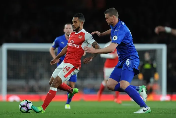 Framed Print : Arsenal's Theo Walcott Faces Off Against Leicester's Robert Huth in Intense Premier League Clash Framed Print : Arsenal's Theo Walcott Faces Off Against Leicester's Robert Huth in Intense Premier League Clash