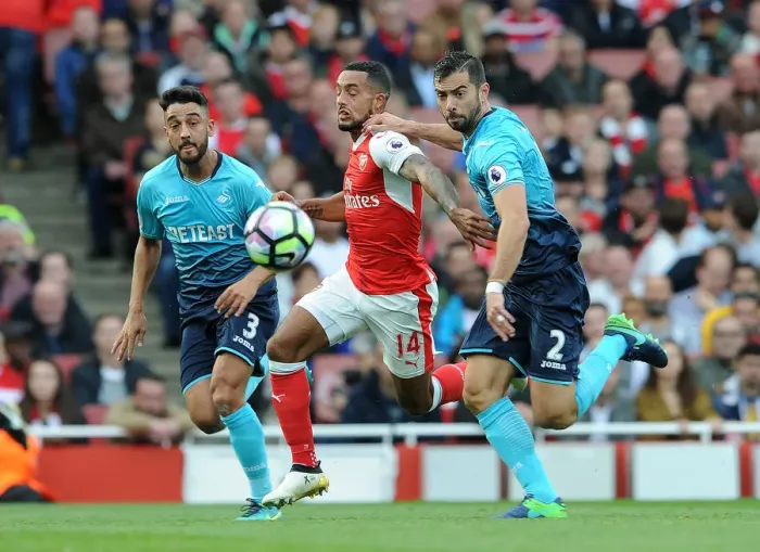 Framed Print : Arsenal's Theo Walcott Faces Off Against Swansea Defenders in Intense Battle
