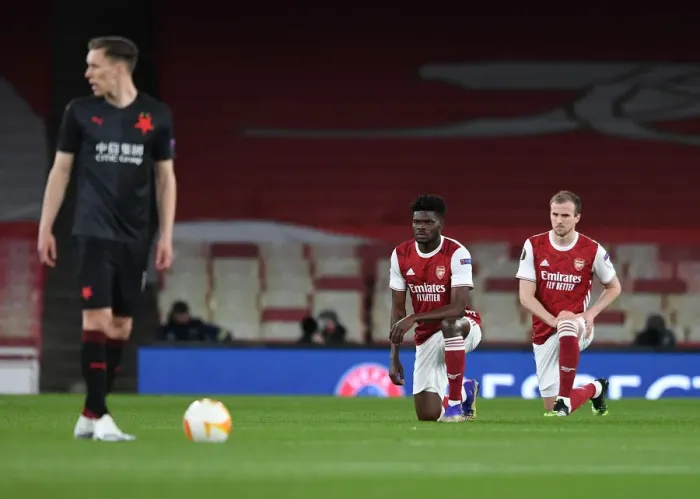 Framed Print : Arsenal's Thomas Partey and Rob Holding Kneel during Empty Emirates Stadium for Europa League Quarterfinal vs Slavia Praha