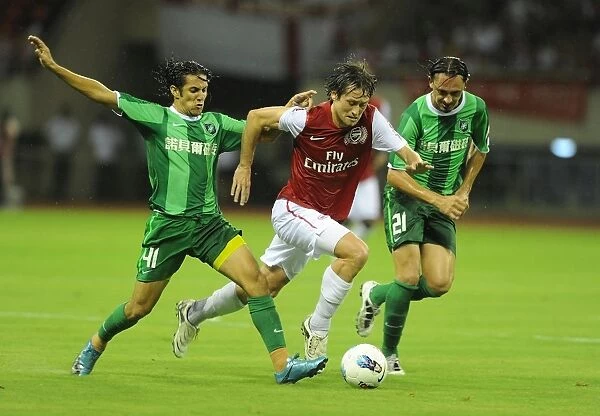 Arsenal's Tomas Rosicky Faces Off Against Hangzhou Greentown's Pezzolano and Vazquez