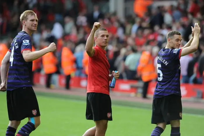 Framed Print : Arsenal's Triumph: Mertesacker, Podolski, and Vermaelen's Victory Dance (Liverpool 2012)