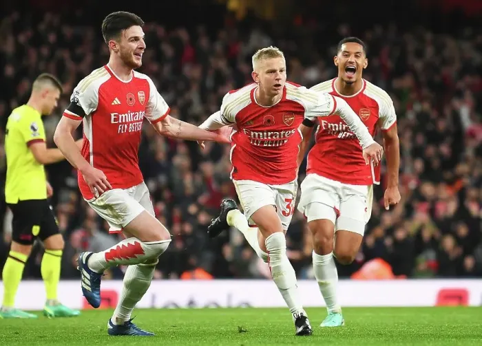 Framed Print : Arsenal's Triumph: Zinchenko, Rice, and Saliba's Euphoric Celebration After Scoring the Third Goal vs. Burnley (2023-24)