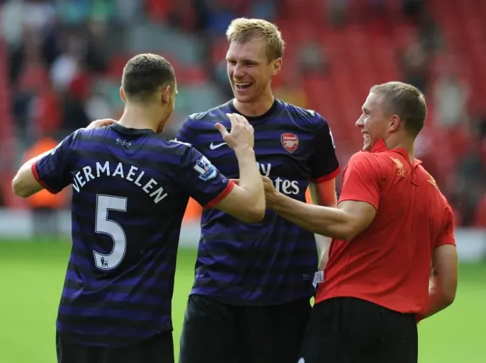 Framed Print : Arsenal's Triumphant Trio: Vermaelen, Mertesacker, Podolski Celebrate Victory at Anfield