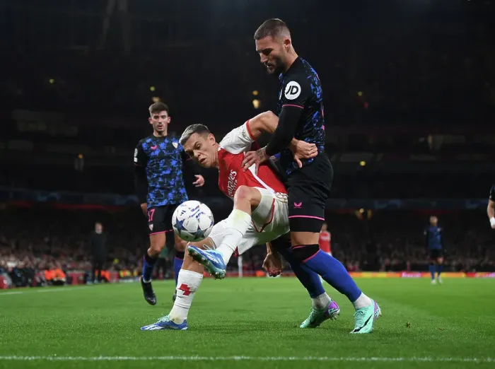 Framed Print : Arsenal's Trossard Fends Off Sevilla's Gudelj in Intense UCL Showdown