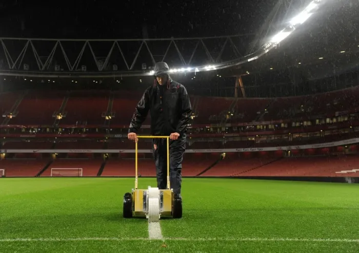 Framed Print : Arsenal's Unyielding Groundsman: Sion Bennett Braves the Rain to Prepare for Arsenal vs. Chelsea Showdown