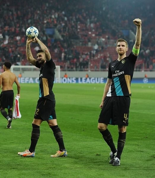 Arsenal's Victory Celebration: Giroud and Mertesacker Embrace after Winning against Olympiacos
