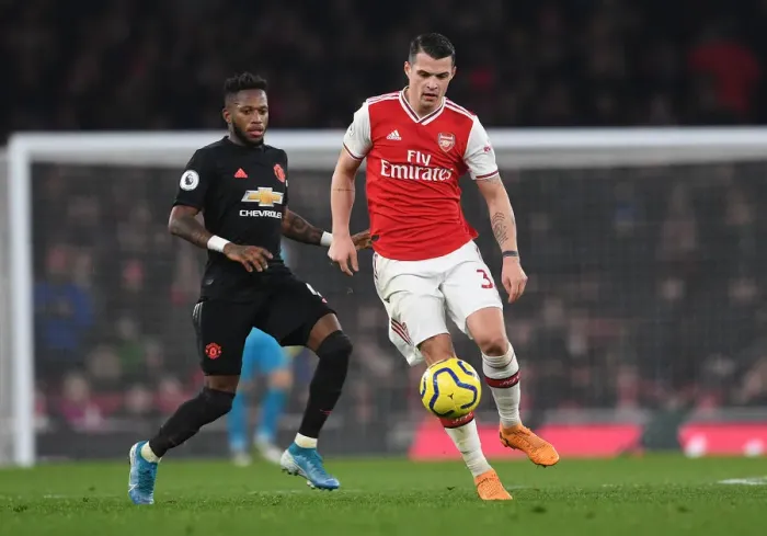 Framed Print : Arsenal's Xhaka Clashes with Manchester United's Fred in Intense Premier League Showdown Framed Print : Arsenal's Xhaka Clashes with Manchester United's Fred in Intense Premier League Showdown