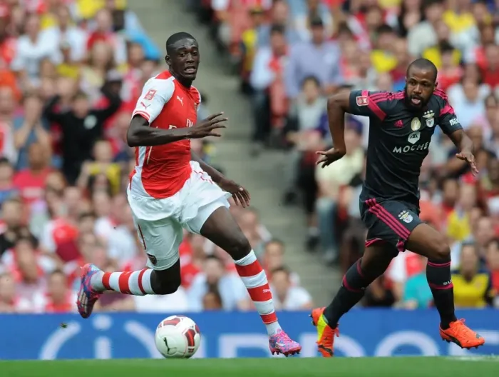 Framed Print : Arsenal's Yaya Sanogo Outmaneuvers Benfica's Eliseu in Emirates Cup Clash