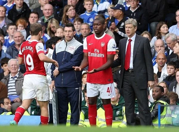 Arsene Wenger the Arsenal Manager with Jay Emmanuel Thomas who is coming on for Jack Wilshere