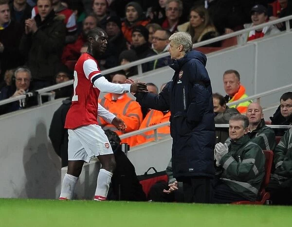 Arsene Wenger the Arsenal Manager shakes hands with Yaya Sanogo (Arsenal) as he comes off as a sub