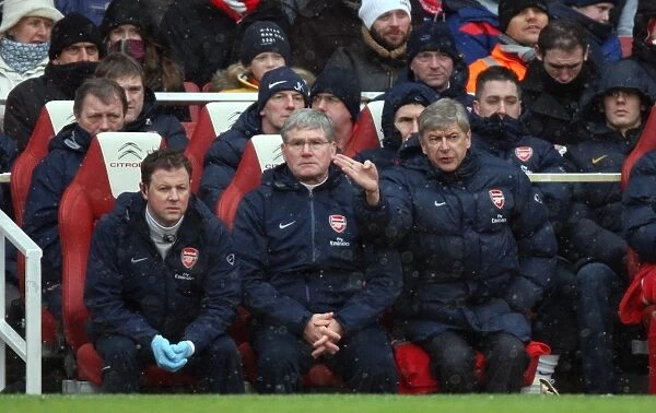 Arsene Wenger the Arsenal Manager sits in the dug out with Pat Rice (Assistant Manager)