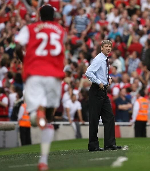 Arsene Wenger watches Emmanuel Adebayor celebrate scoring Arsenals 2nd goal his 1st