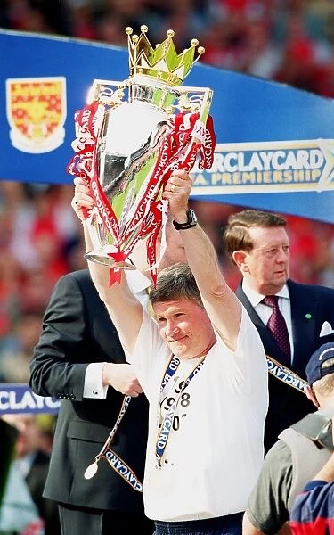 Assistant manager Pat Rice lifts the F.A.Barclaycard Premiership Trophy