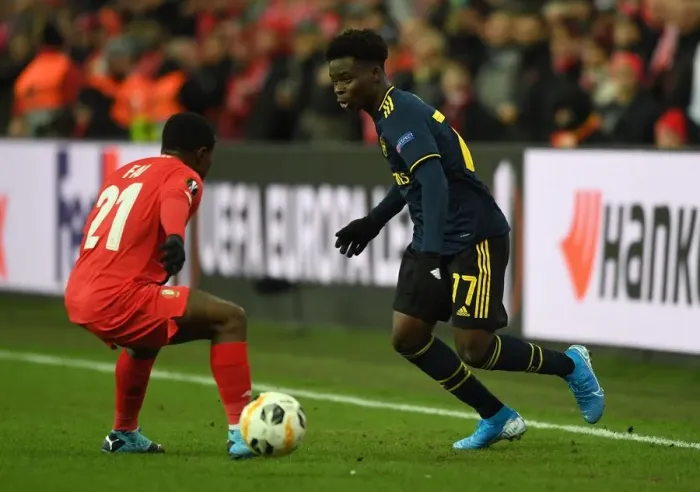 Framed Print : Bukayo Saka Faces Off Against Collins Fai in Arsenal's Europa League Clash with Standard Liege