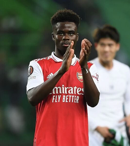 Bukayo Saka's Euphoric Moment: Arsenal's Victory Applause at Sporting Lisbon's Estadio Jose Alvalade - Arsenal's Triumph in the UEFA Europa League 2022-23 Round of 16 (Lisbon, Portugal - March 9, 2023)
