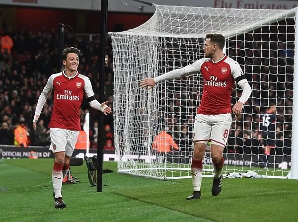 Celebrating Goal: Ozil and Ramsey Rejoice After Sanchez's Strike in Arsenal's Victory vs. Huddersfield Town
