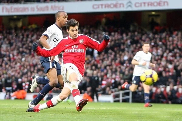 Cesc Fabregas scores his and Arsenals 2nd goal under pressure from Fabian Delph
