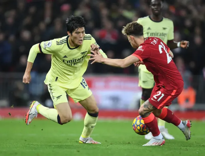 Framed Print : Clash at Anfield: Tomiyasu vs. Tsimikas in Premier League Showdown