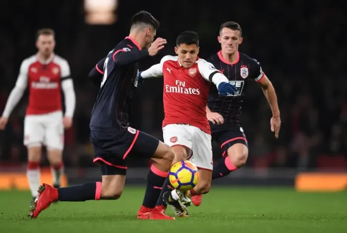 Framed Print : Clash of Champions: Sanchez vs. Schindler in Arsenal's Battle against Huddersfield