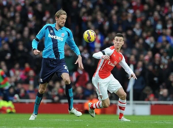 Clash at Emirates: Koscielny vs. Crouch in Arsenal's Battle Against Stoke City (2014-15)