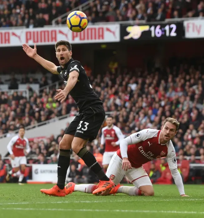 Framed Print : Clash at the Emirates: Ramsey vs. Fernandez in Arsenal's Battle Against Swansea City Framed Print : Clash at the Emirates: Ramsey vs. Fernandez in Arsenal's Battle Against Swansea City