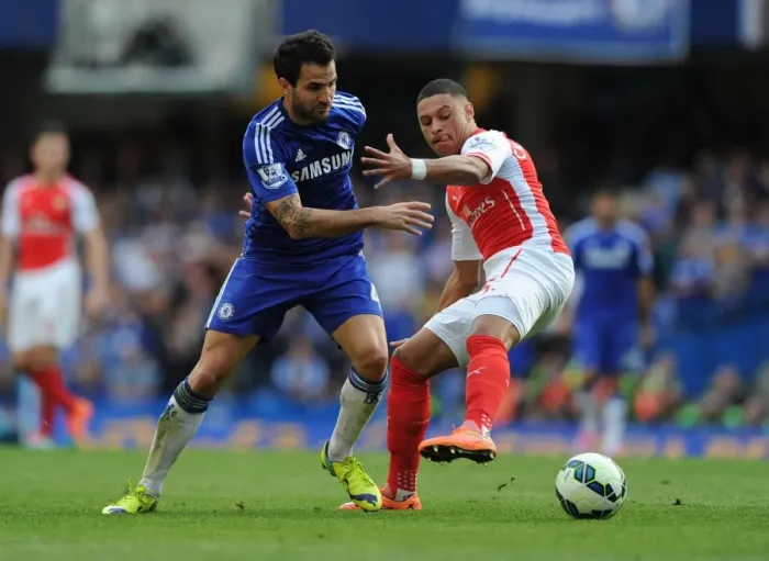 Framed Print : Clash of the Midfield Maestros: Oxlade-Chamberlain vs. Fabregas - A Premier League Battle