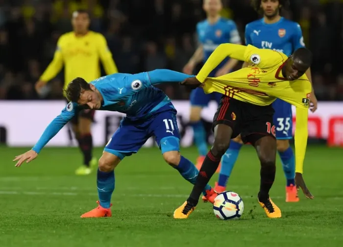 Framed Print : Clash on the Pitch: Ozil vs. Doucoure in the Premier League Battle between Watford and Arsenal Framed Print : Clash on the Pitch: Ozil vs. Doucoure in the Premier League Battle between Watford and Arsenal