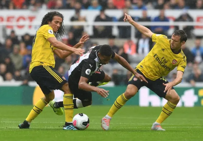 Framed Print : Clash at St. James Park: Arsenal's Guendouzi and Monreal Face Off Against Newcastle's Hayden (Newcastle United vs Arsenal, 2019-20)