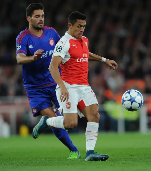 Framed Print : Clash of Stars: Alexis Sanchez vs. Alberto Botia in Arsenal's Champions League Battle against Olympiacos Framed Print : Clash of Stars: Alexis Sanchez vs. Alberto Botia in Arsenal's Champions League Battle against Olympiacos