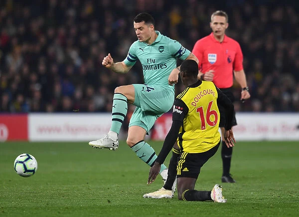 Clash at Vicarage Road: Xhaka vs. Doucoure in the Premier League Battle between Watford and Arsenal