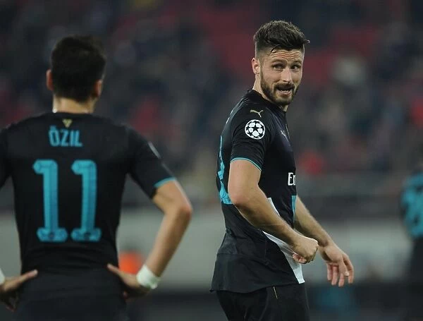 Deep in Thought: Giroud and Ozil's Intense Conversation on the Arsenal Bench during Olympiacos Match, UEFA Champions League, 2015