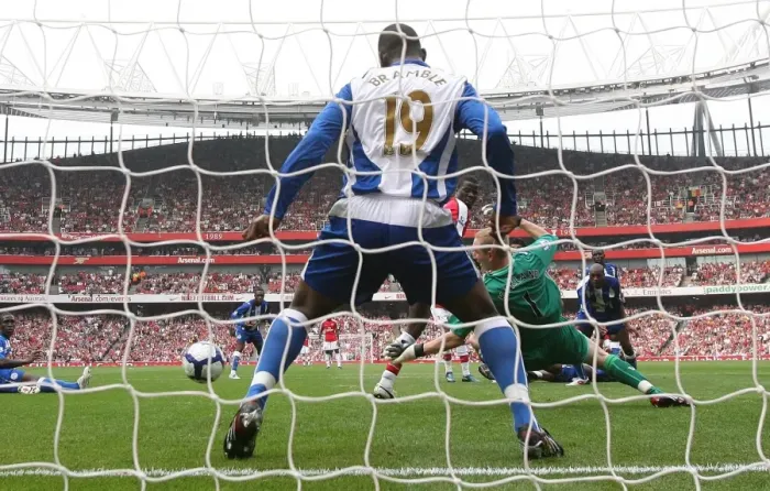 Framed Print : Emmanuel Eboue deflects the ball past Wigan goalkeeper Framed Print : Emmanuel Eboue deflects the ball past Wigan goalkeeper