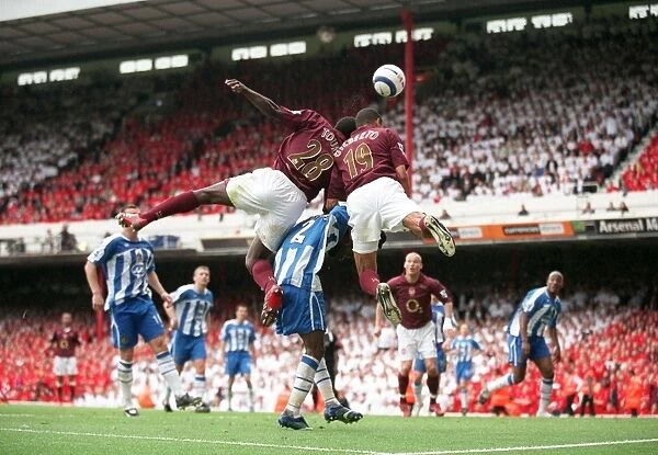 Gilberto and Kolo Toure (Arsenal) jump for the ball with Pascal Chimbonda (Wigan)