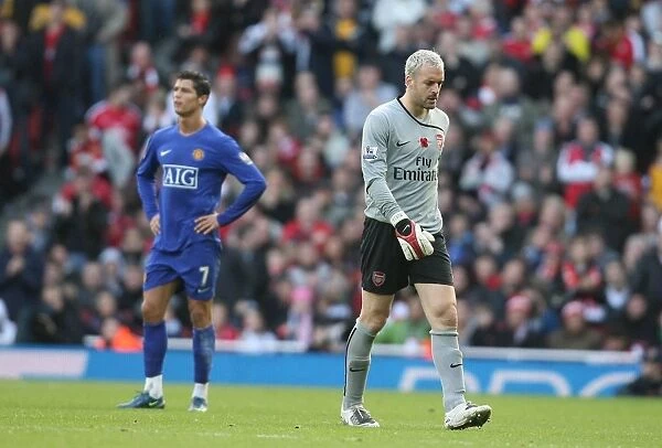 Injured Arsenal goalkeeper Manuel Almunia leaves the field