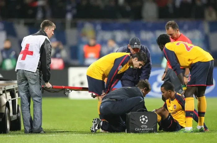 Framed Print : Injured Theo Walcott is treated by Arsenal physio Colin Lewin