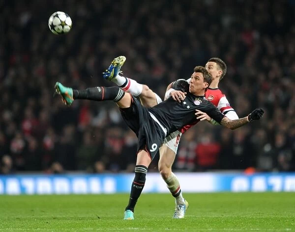 Intense Battle: Koscielny vs. Mandzukic in Arsenal's Champions League Showdown against Bayern Munich