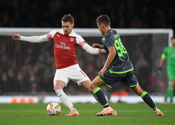Intense Clash: Aaron Ramsey vs. Miquel Luis in Arsenal's Europa League Battle against Sporting CP