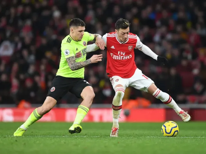 Framed Print : Intense Clash: Ozil vs. Baldock in Arsenal's Premier League Battle against Sheffield United Framed Print : Intense Clash: Ozil vs. Baldock in Arsenal's Premier League Battle against Sheffield United