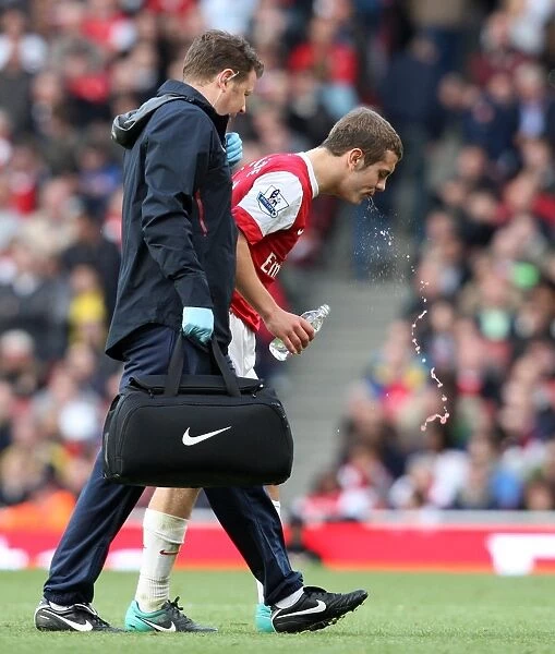 Jack Wilshere (Arsenal) gets treatment for a bloody lip from Physio Colin Lewin
