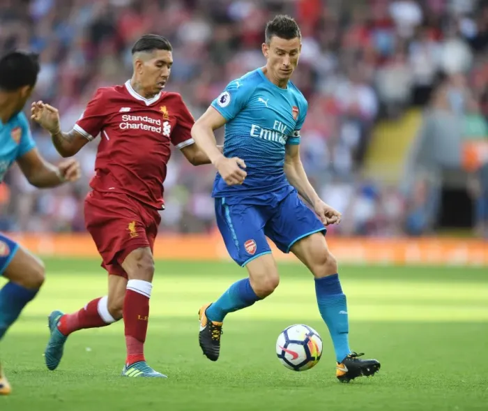 Framed Print : Koscielny vs. Firmino: A Premier League Battle at Anfield Framed Print : Koscielny vs. Firmino: A Premier League Battle at Anfield