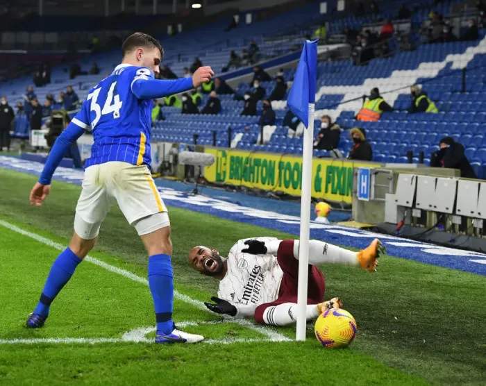 Framed Print : Lacazette Fouls Bissouma: Premier League Showdown Between Arsenal and Brighton at Empty American Express Community Stadium