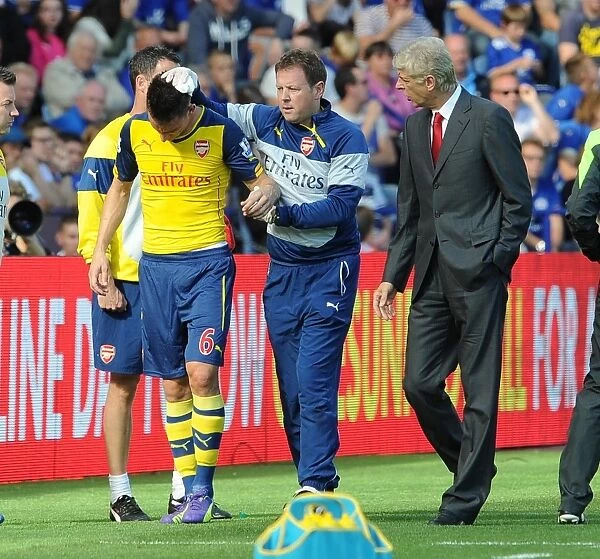 Laurent Koscielny (Arsenal) with Physio Colin Lewin and Arsene Wenger the Arsenal Manager