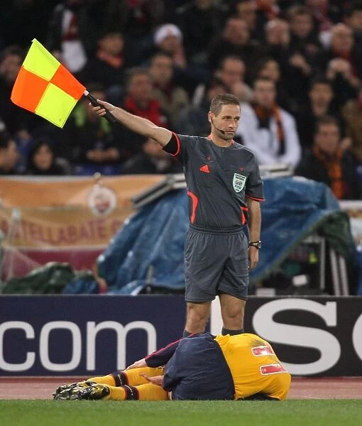 The linesman stands over injured Robin van Persie (Arsenal)